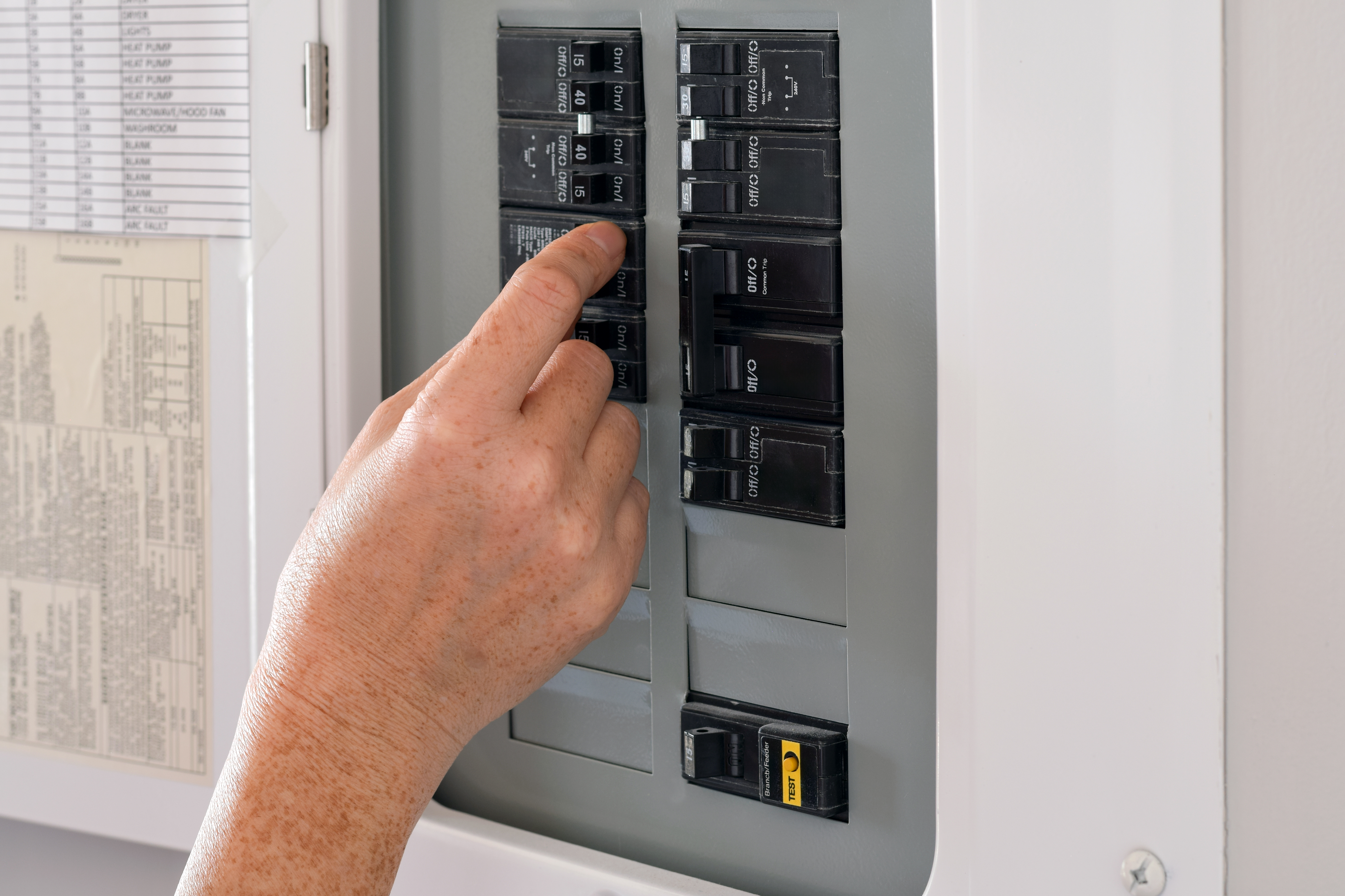 Hand adjusting a circuit breaker in a home 2026 03 27 02 19 26 utc